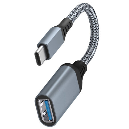 USB Type-C OTG cable connecting a smartphone to a flash drive in a European workspace